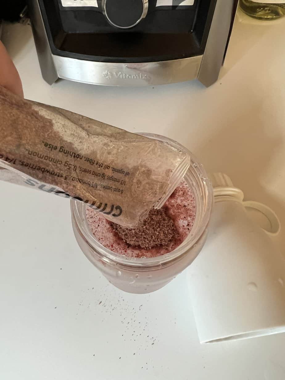 pouring Kencko smoothie into water